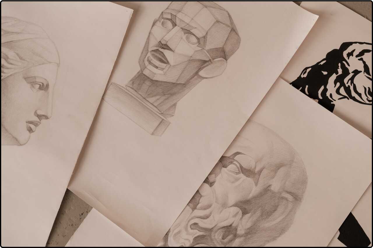 Close-up of artistic sketches on paper, showing various drawing techniques in an art studio.